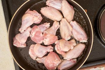 chicken wings frying with oil on a hot pan