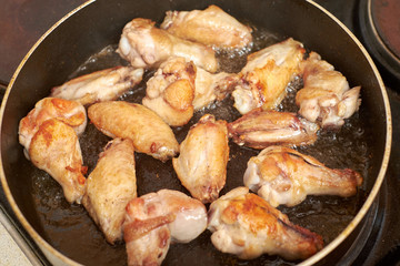 Chicken wings fried in pan with hot oil, homemade food