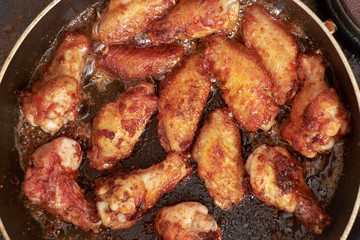 chicken wings frying with oil on a hot pan