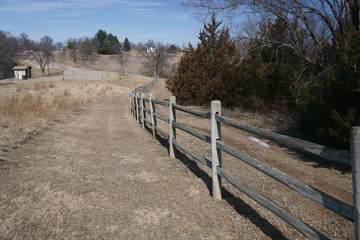 Fototapeta na wymiar View of a wood fence running thru the tall prairie grass and cedar trees.