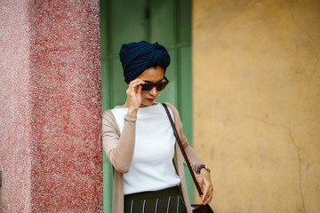 Fashion portrait of a young, slim and attractive Muslim Malay woman in a turban head scarf. She is...