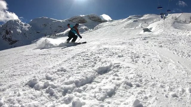 Young boy skiing.
A man enjoys skiing in the Alpine resort. Skier spraying snow into the camera. Stabilized footage. Slow motion.

