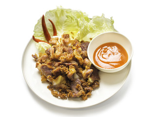 Fried sour pork, fermented pork with sauce, vegetable and chili on dish isolated on white background. sour pork is faverite presevation food in thailand. clipping path included.
