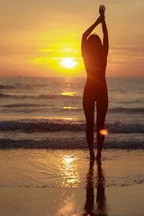 Obraz na płótnie Canvas Beautiful model under the sunrise at seaside