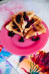 Breakfast: pancakes with blueberry berries, currants on a pink plate in the style of Provence.. dessert