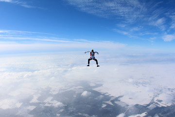 Naklejka na ściany i meble Skydiver is flying in the winter sky.