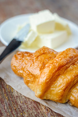 Croissant close-up and butter on a wooden table