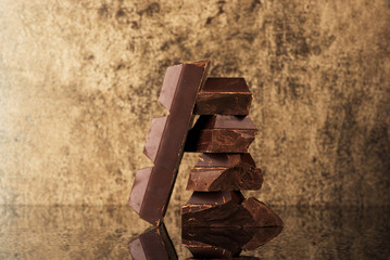 Stack and block chocolate on a gold stone background