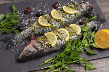 two seabass fish in marinade with spices and lemon, raw fish