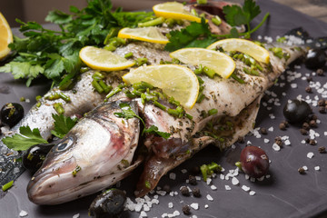 two seabass fish in marinade with spices and lemon, raw fish