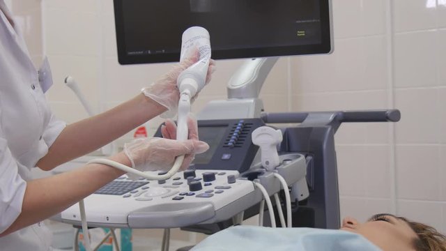 The doctor applies a gel to the probe of ultrasound equipment
