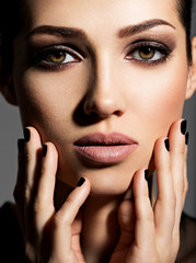 Face of a beautiful girl with fashion makeup and black nails