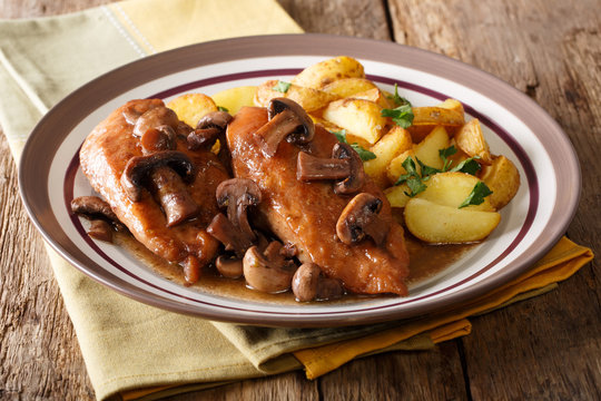 Italian American food: Chicken in Marsala wine with fried mushrooms and potatoes close-up. horizontal