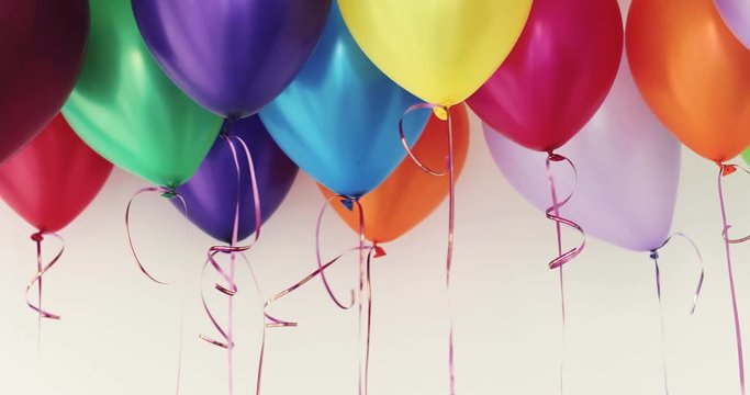 Colorful balloons waving in the interior of a white room background