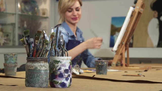 Selective focus on paintbrushes copy space professional female creative artist painter working on her painting on the background drawing artwork relaxation hobby lifestyle leisure design creative.