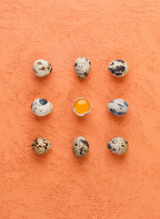 Quail eggs on a textured orange background. Food concept..