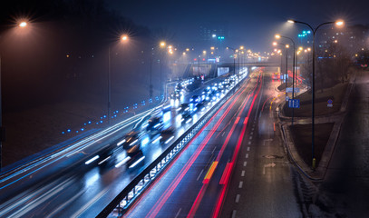 Raint Night Traffic - cars driving down a busy city thoroughfare with lightstreaks. - 196134204