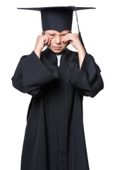Sad crying disappointed graduate little girl student in black graduation gown with hat - isolated on white. Negative human emotion facial expression. Child back to school, educational concept.