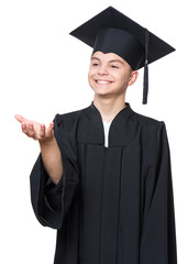 Portrait of graduate teen boy student in black graduation gown with hat - isolated on white background. Child back to school and educational concept.