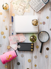 Calculator with money and pennies on a wooden green background. Business concept