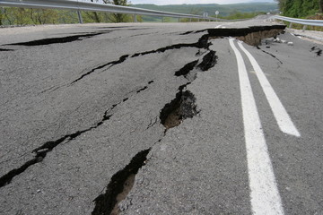 Road collapses with huge cracks. International road collapsed down after bad construction. Damaged Highway Road. Asphalt road collapsed and fallen. Erosion. 