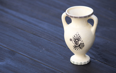 Ancient amphora (jug) on a black wooden background
