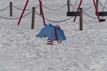 Swing shaped as a dolphin at a snowy playground © Hans Baath