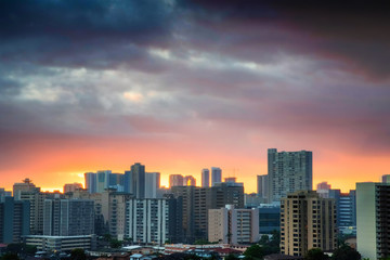 Fototapeta na wymiar Sunset over urban concrete jungle - residential buildings in Honolulu, Hawaii - on a cloudy day