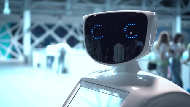 Modern Robotic Technologies. The robot looks at the camera at the person. The robot shows emotions. The robot looks at the camera at the person.