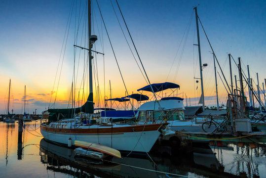 Small vessels docked at Ala Wai Boat Harbor in Honolulu, Hawaii at sunset