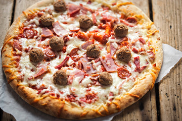 Meat feast pizza with ham, bacon, beef