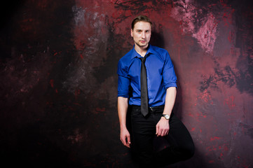 Studio portrait of stylish man, wear on blue shirt and necktie.