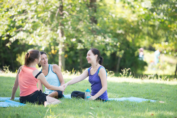 Families with young Russian mother and daughter are talk about exercise. After practice yoga at the park finished. Health and Fitness concept