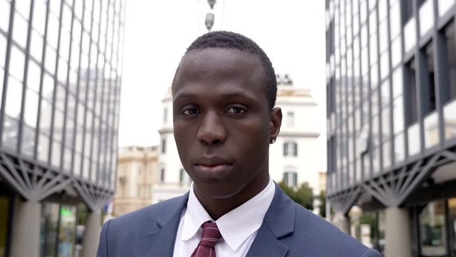 Confident handsome black african business man in teh street looking at camera