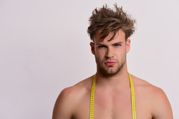 Athlete with messy hair measures body. Sports and weight loss