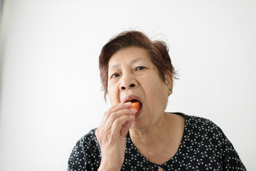 Asian senior woman eating ripe papaya sliced at home, lifestyle concept.