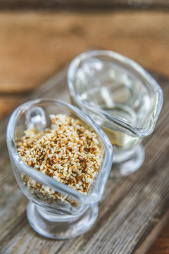 sesame seed oil and sesame seed oil in glass Cup on natural wooden background, healthy food concept, organic food.