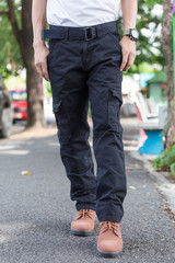 man wearing black cargo pants and standing in the nature park