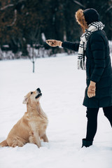 Picture of woman playing with dog in winter park