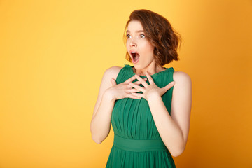 portrait of young shocked woman looking away isolated on orange