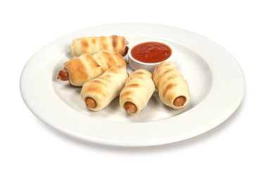 sausages baked in dough on a plate with sauce