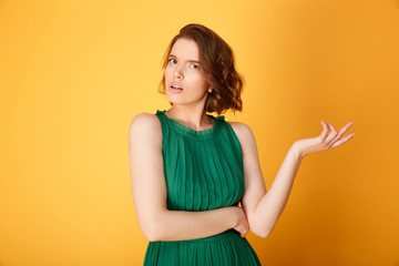 Obraz premium portrait of young confused woman isolated on orange