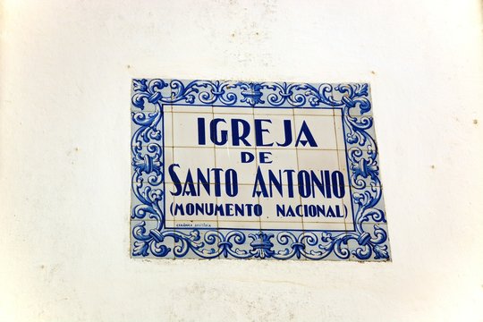 Ceramic sign for the Santo Antonio Church written in Portuguese on the wall, Lagos, Algarve, Portugal.