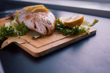 Fresh trout and ingredients to prepare fish dishes on black table