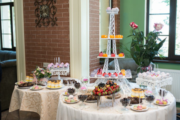 Tray for cakes in the form of an Eiffel tower. Candy bar. A lot of sweets at the wedding banquet. 