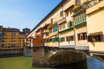 Fototapeta na wymiar Side view of medieval stone bridge Ponte Vecchio over the Arno River in Florence,