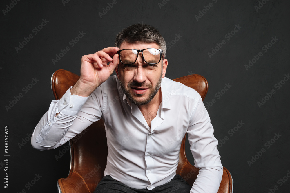 Wall mural Concentrated businessman wearing glasses looking camera.