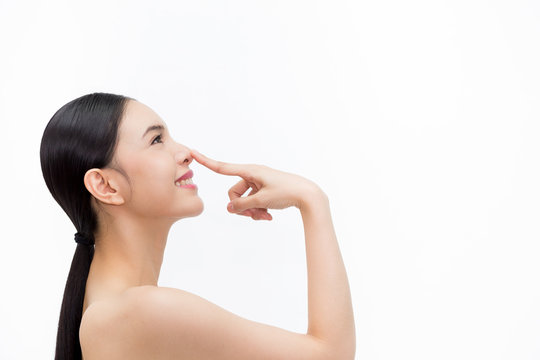 Young attractive woman touching her nose with fingertip over isolated white background.