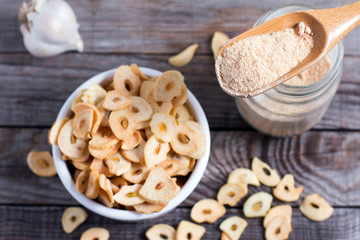 Spoon with granulated dried garlic on wooden background
