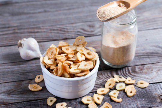 Spoon with granulated dried garlic on wooden background
